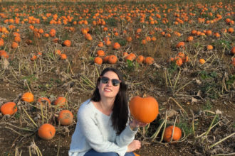 Elle Croft posing with pumpkin in field: Pumpkin Picking in Kent