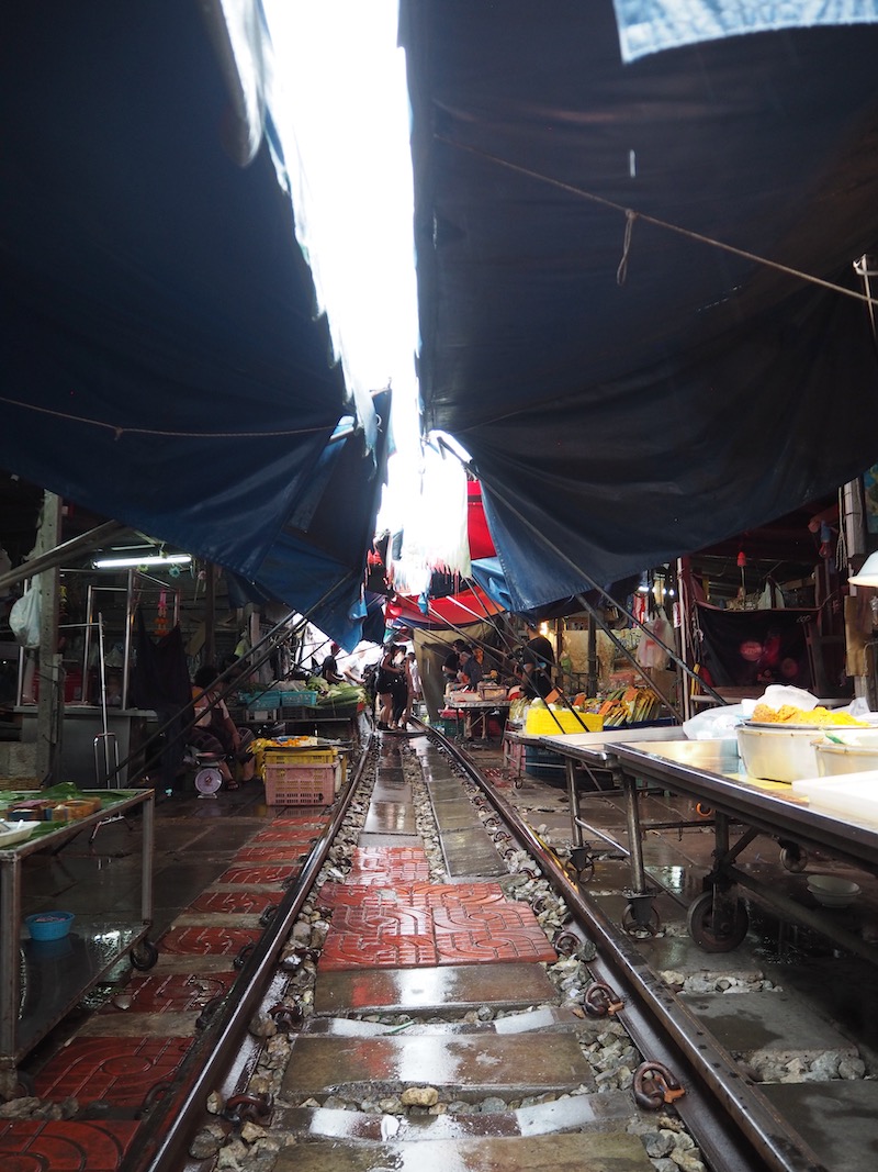 Train tracks with market awnings overhead at Rom Hoops Market, Thailand