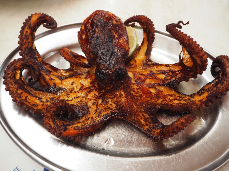 Whole chargrilled octopus on a silver platter