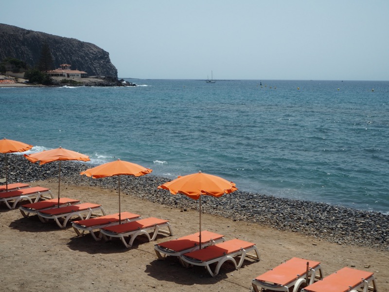 One of the reasons to visit Tenerife is beaches like this one: golden sand, blue sea and skies, and pretty orange umbrellas dotting the beach